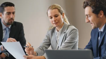 Three professionals discussing a document